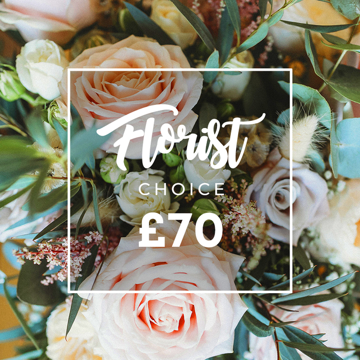 A warm, close overhead portrait of a florist's signature hand-picked bouquet, composed in soft, romantic pastels and photographed with flattering natural light to reveal every texture. Dominant are generous roses in blush pink, creamy ivory and soft peach, their petals opening with a delicate, tactile richness; pockets of muted lavender and dusty mauve roses add gentle contrast and a layered, painterly depth. Between these principal blooms, clusters of tiny white filler flowers and light pink waxflower buds trace intricate, lace-like patterns, while small pink berry clusters provide charming points of interest. The arrangement is enlivened by fluffy dried elements-cream and tan grasses and seed-heads-that introduce a rustic, garden-harvest feel and add sculptural volume. Broad, rounded eucalyptus leaves in a cool blue-green weave through the composition, offering structural elegance, a whisper of scent and a verdant backdrop that makes the pastel tones sing. Over the centre of the bouquet a neat white rectangular frame is superimposed; within it, elegant script proclaims Florist Choice, beneath which the smaller uppercase CHOICE appears, and the price ?70 is displayed in bold white figures at the bottom. This bouquet feels bespoke and slightly wild, the sort of artisan design a local florist might prepare for weddings, milestone birthdays or gentle celebrations across Tottenham-from High Road addresses to the terraces near Tottenham Hale. Crafted with attentive seasonality and a polished, yet relaxed aesthetic, it reads as a thoughtful, premium choice for delivery locally from Flowers Tottenham.